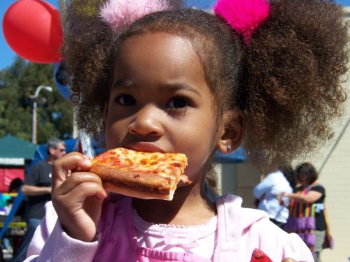 Four-year-old Niko Vest Walton savors a slice of pizza at a Purim Carnival in Culver City, California. Copyright 2008 Corinne Lightweaver.